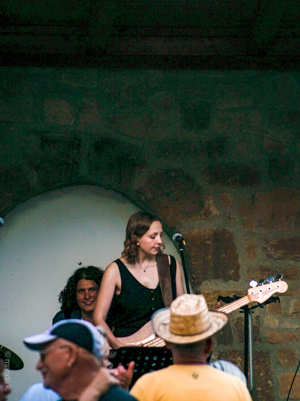 Auf dem Bild sieht man Charlotte, welche Bass spielt. Tobi sitzt im Hintergrund auf der Cajon und grinst in Richtung Kamera